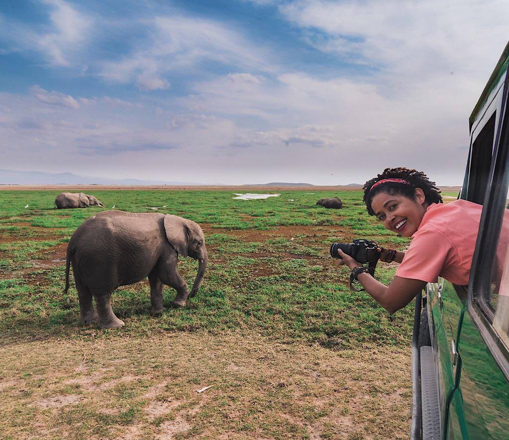 A lady taking photos of an elephant